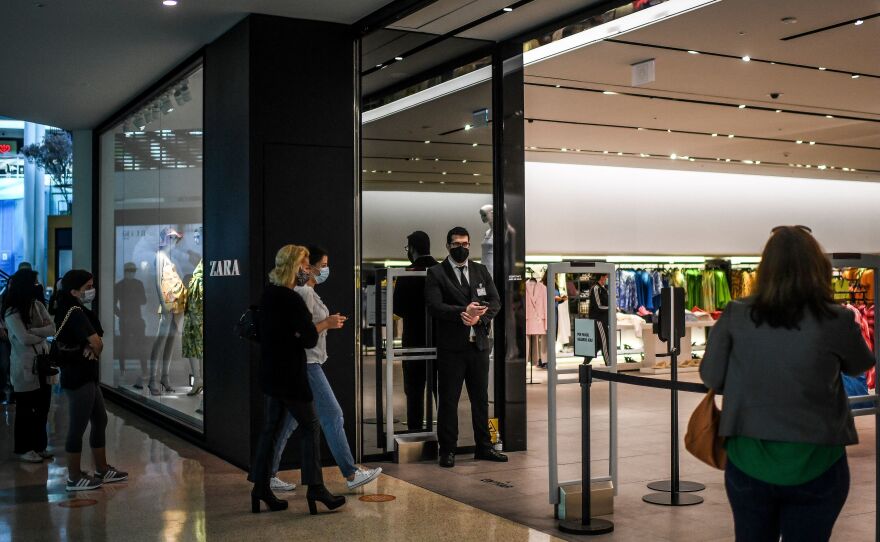 Customers queue to enter a re-opened Zara clothes shop at Colombo shopping center in Lisbon, Portugal, on in April 2021.