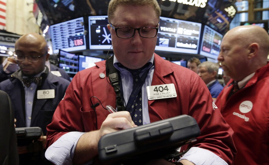 Trader Ryan Falvey (center), works on the floor of the New York Stock Exchange on Wednesday. Stocks were modestly higher in early trading on Wall Street Wednesday as the Federal Reserve ends its last two-day policy meeting of 2013.