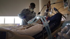 In this Dec. 22, 2020, file photo, Dr. Mher Onanyan tends to a COVID-19 patient at Providence Holy Cross Medical Center in the Mission Hills section of Los Angeles. 