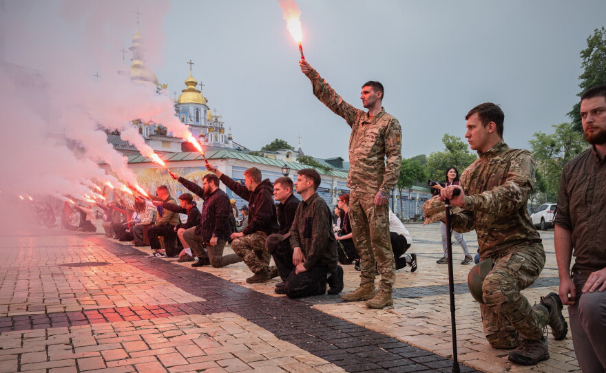 People light up flares during the funeral ceremony of fallen Ukrainian serviceman Yaroslav Ivanov in Kyiv, Ukraine, on June 8.
