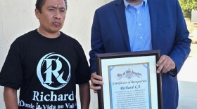 Carlitos Ricardo Parias (left) receives a certificate of recognition from Jose Ugarte, chief of staff for Los Angeles City Council member Curren Price, in Los Angeles in August 2025.