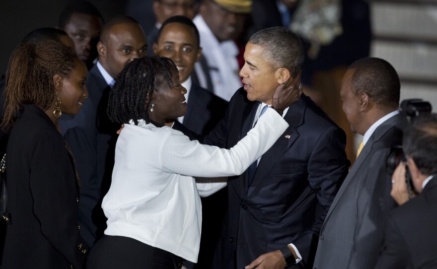 President Obama is hugged by his half-sister Auma Obama, accompanied by Kenya's President Uhuru Kenyatta (right) as he arrives at the Jomo Kenyatta International Airport in Nairobi on Friday.