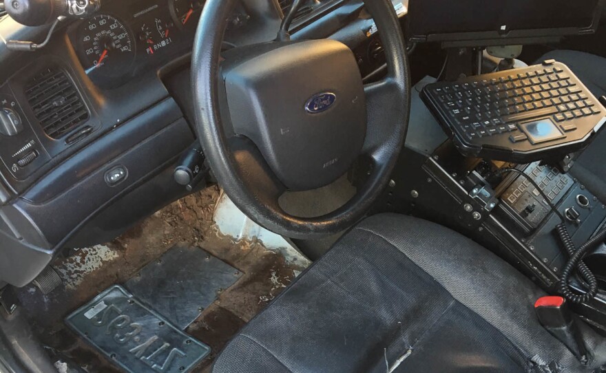 Holes in the floorboards of a New Haven Police Department squad car have been patched with an old license plate.