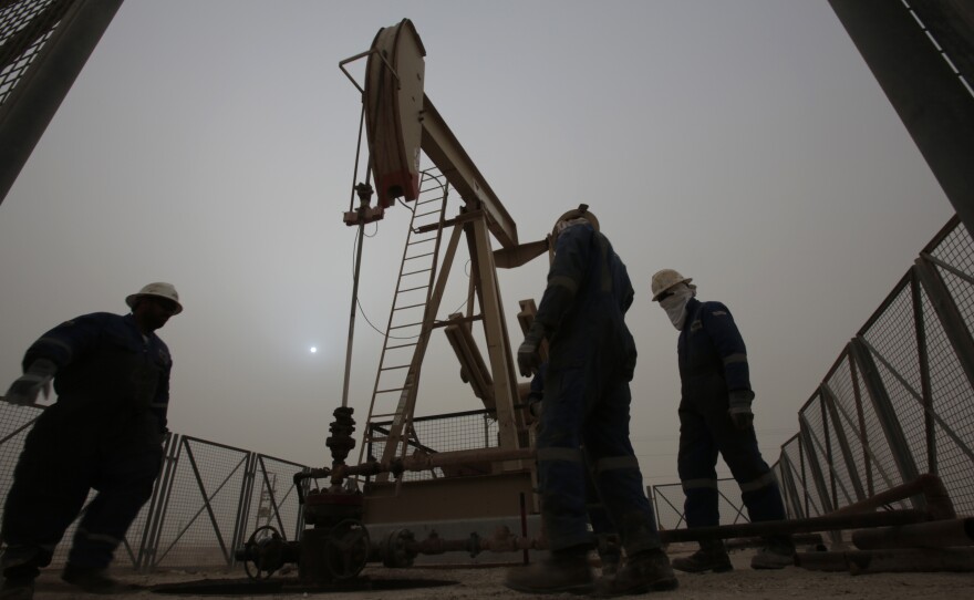 Men work on an oil pump during a sandstorm in the desert oil fields of Sakhir, Bahrain, in January.