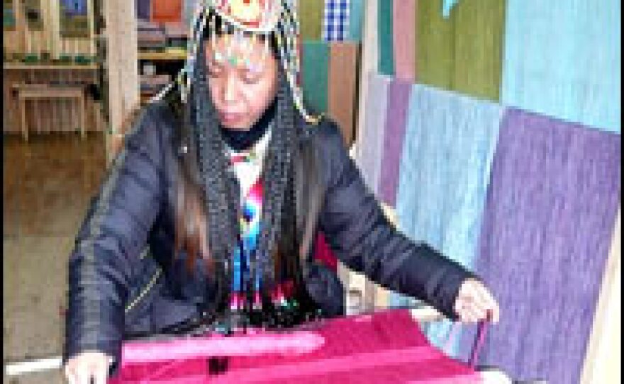 Tibetans sell scarves woven using traditional looms in the old town.