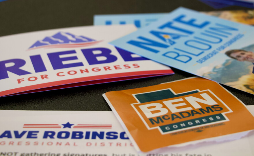 Candidate handouts are displayed at an event for candidates running to represent Utah's new Democratic-leaning congressional district in Taylorsville, Utah on March 21. While some candidates have since dropped out, four remain including former Rep. Ben McAdams and state Sen. Nate Blouin.