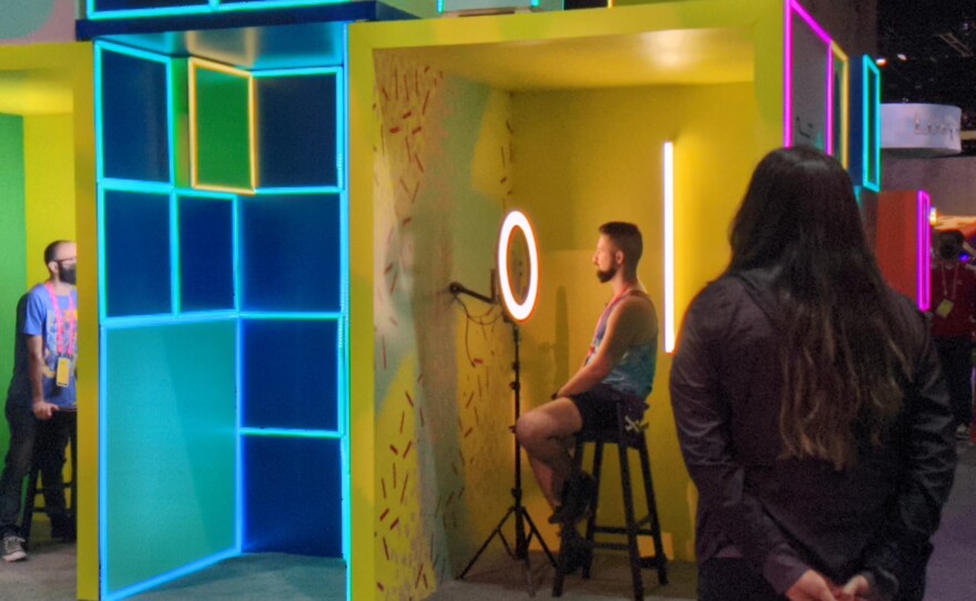 Streamers making their emotes at the Emotifier at TwitchCon while a staff member looks on, Oct. 8, 2022.