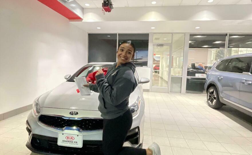Reyna Garcia's daughter Kira Gray poses in front of the used Kia Forte the family recently bought.