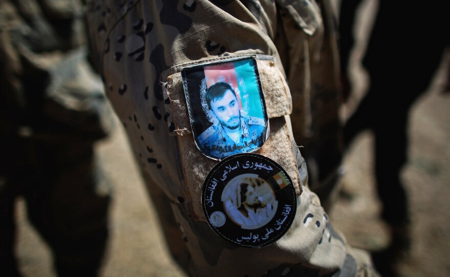 A patch on an Afghan National Police officer's uniform features the face of Raziq.