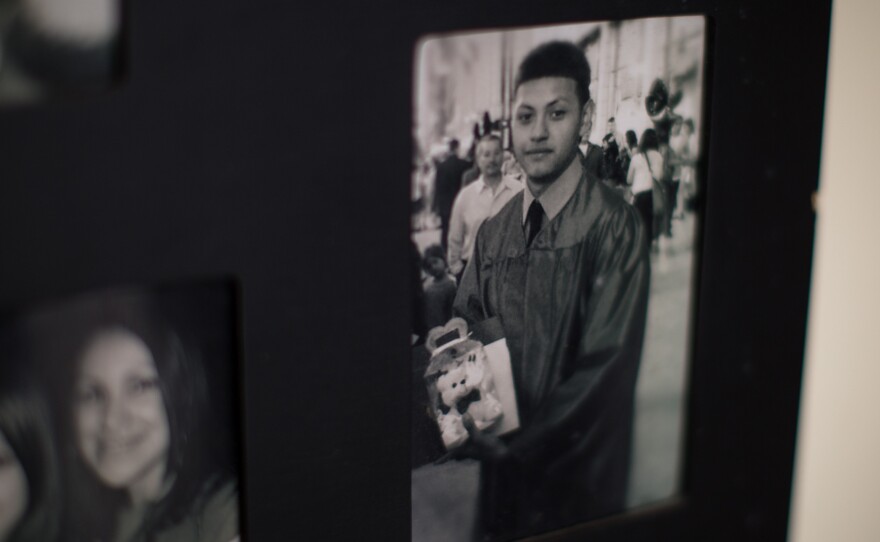 A photograph of Kevin Lopez at his high school graduation hangs on the wall at home. At 18, he was put on a waiting list to receive a hand transplant.