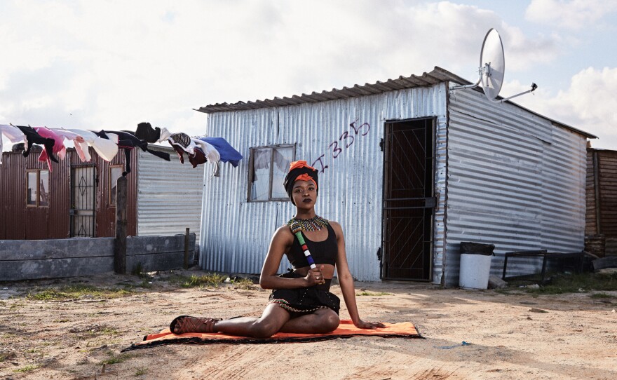 Mthulic Vee Vuma, a 21-year-old studying public management at West Coast College, wears traditional Xhosa clothing and jewelry in front of a shack in Khayelitsha. "The meaning of the clothing I am wearing is to love and accept our culture," Vuma says. Her family initially struggled to accept her as a trans woman, believing it was a curse, but she says they now give her total support.
