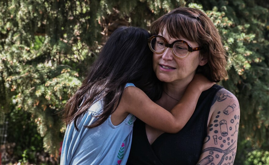 Jeni Rae Peters and daughter embrace at their home in Rapid City, S.D. In 2020, Peters was diagnosed with stage 2 breast cancer. After treatment, Peters estimates that her medical bills exceeded $30,000.