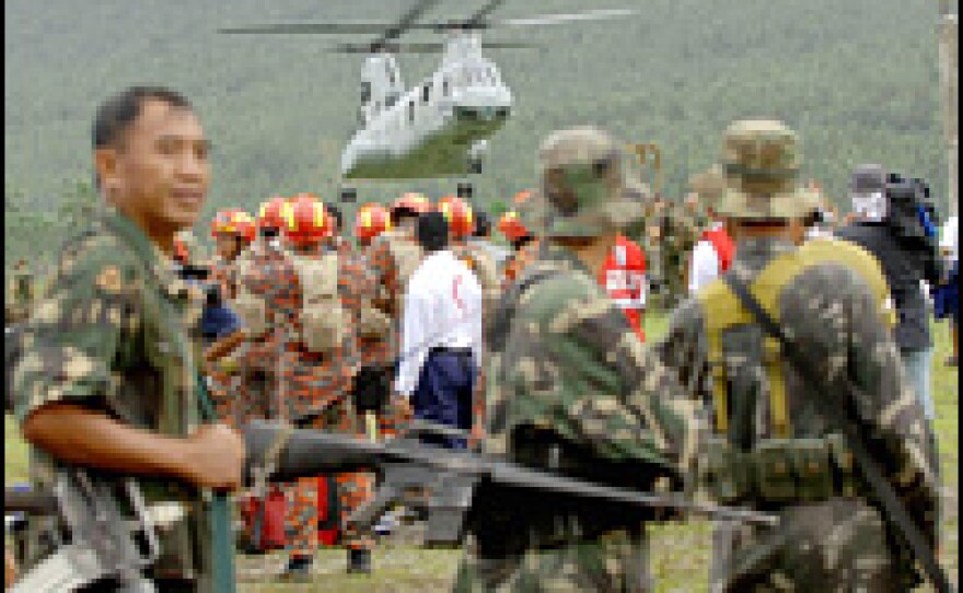 A U.S. Chinook helicopter drops off logistical supplies and military personnel at the command base for rescue operations near the devastated village of Guinsaugon in central Philippines, Feb. 20, 2006.