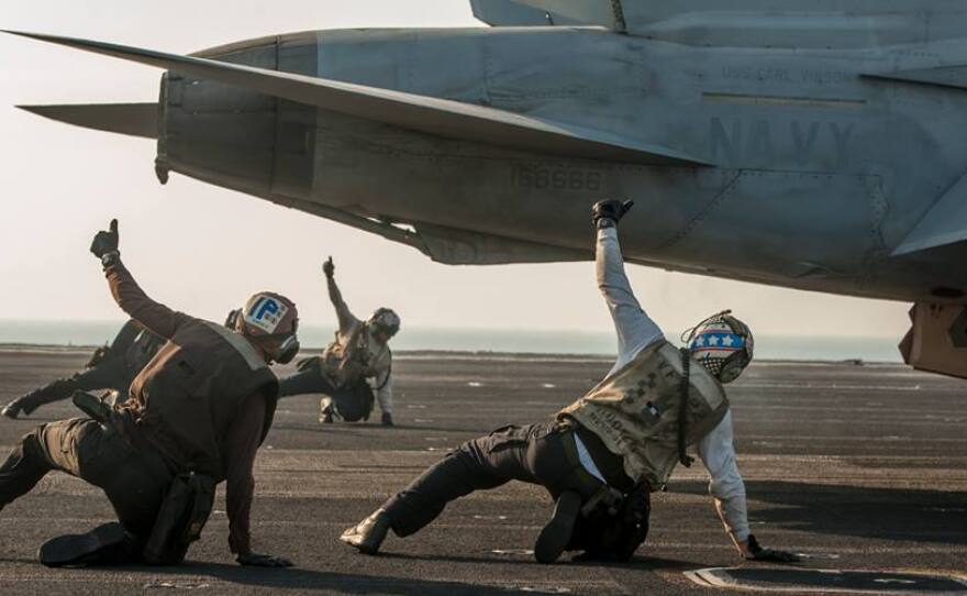 Sailors assigned to the Fighting Redcocks of Strike Fighter Squadron (VFA) 22 signal that an F/A-18F Super Hornet is ready to be launched from the flight deck of the Nimitz-class aircraft carrier USS Carl Vinson (CVN 70) as the ship conducts flight operations in the U.S. 5th Fleet area of responsibility supporting Operation Inherent Resolve.