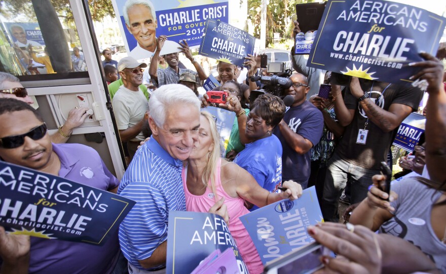 Florida Democratic gubernatorial candidate Charlie Crist, center, gets a kiss from a supporter after he stepped of his bus during a brief campaign stop at Delevoe Park in Fort Lauderdale, Fla., on Oct. 25.