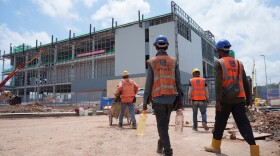 FILE -Construction workers walk to a data center building under construction in Sedenak Tech Park in Johor state of Malaysia, Sept. 27, 2024.