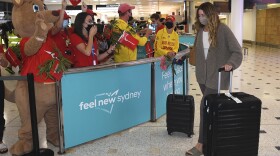 Passengers are welcomed as they arrive at Sydney International Airport on Monday.