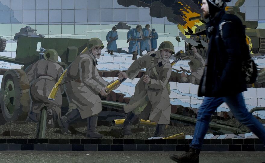 A man walks past a mosaic depicting a World War II battle scene in Rostov-on-Don, a Russian city bordering Ukraine.