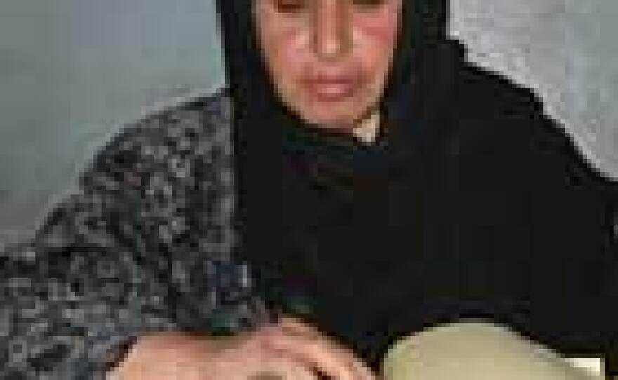 Afghan woman in Kandahar province checks register of women voters.