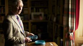 The Prince of Wales with the box of The Queen's cine films is in the Library at Balmoral. 