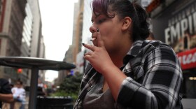 Helene Martich smokes in a Times Square pedestrian island in New York City, something that would be illegal under Mayor Michael Bloomberg's proposed ban on smoking in city parks, beaches, and parts of Times Square.