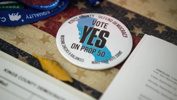 A button reads, “Vote Yes on Prop 50” at the Kings County Democrats booth during the Thursday Night Marketplace in downtown Hanford on Sept. 25, 2025. 