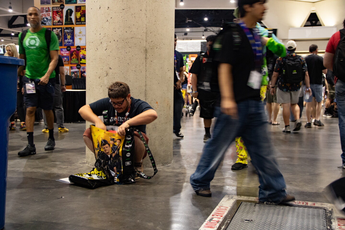 A man searching through his Comic-Con bag as attendees walk pass at Comic-Con, July 23, 2026.