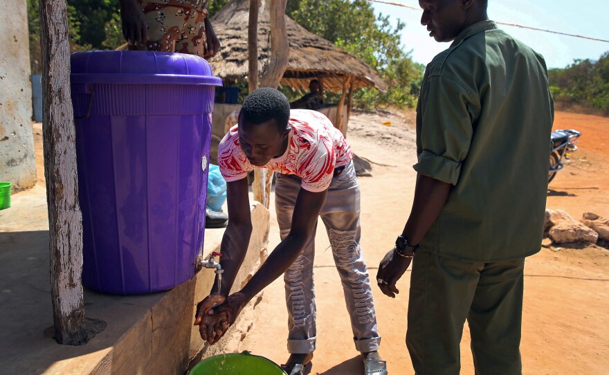 The new normal in Guinea is washing hands with a mixture of water and bleach--shown here at the border entrance of Buruntuma, in the Gabu area on Tuesday.