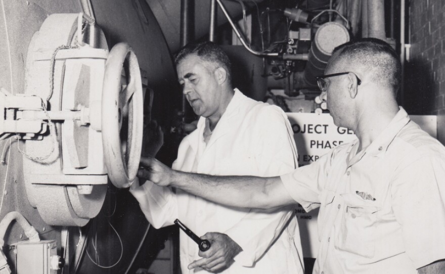 George Bond and Walter Mazzone inspect compression chamber, 1963.