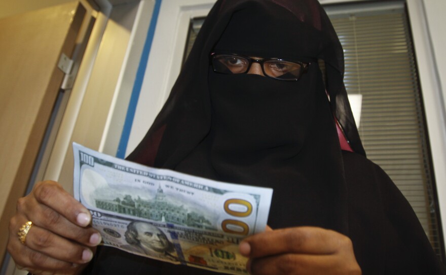 A Somali woman counts the cash she collected from a money transfer service in Mogadishu, the capital city.