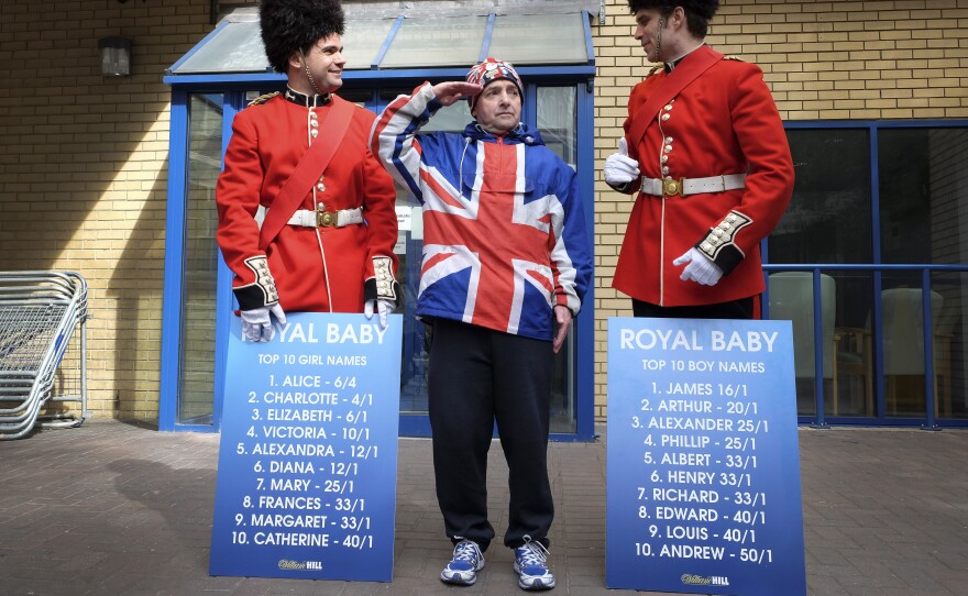 Royal supporter John Loughrey salutes with men dressed as soldiers carrying boards with proposed baby names outside the Lindo Wing of St Mary's Hospital in London on Friday.