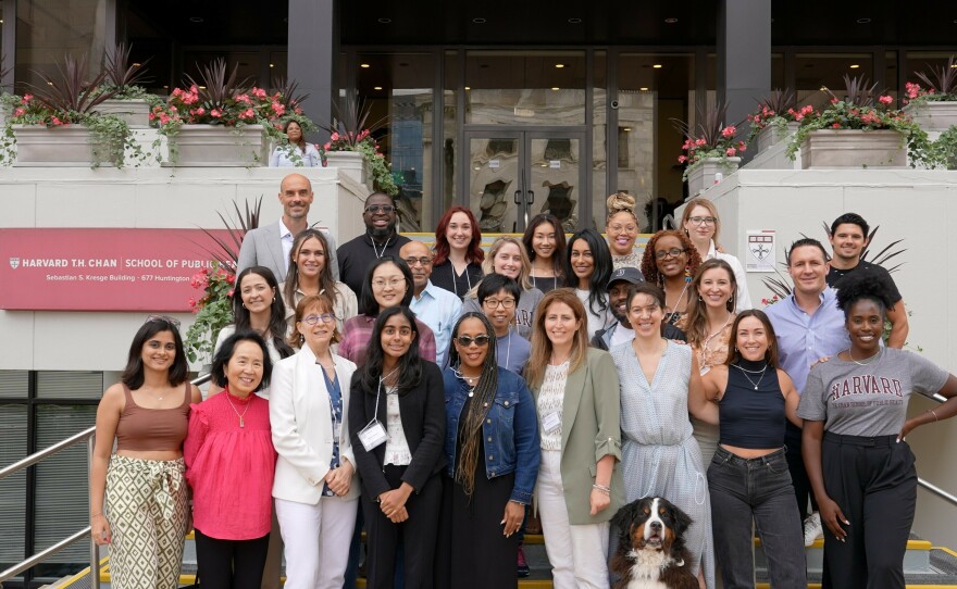 Attendees at a summit for mental health influencers hosted by researchers at the Harvard T.H. Chan School of Public Health. In the front row, right of center, Amanda Yarnell stands next to Kate Speer and her service dog, Waffle.