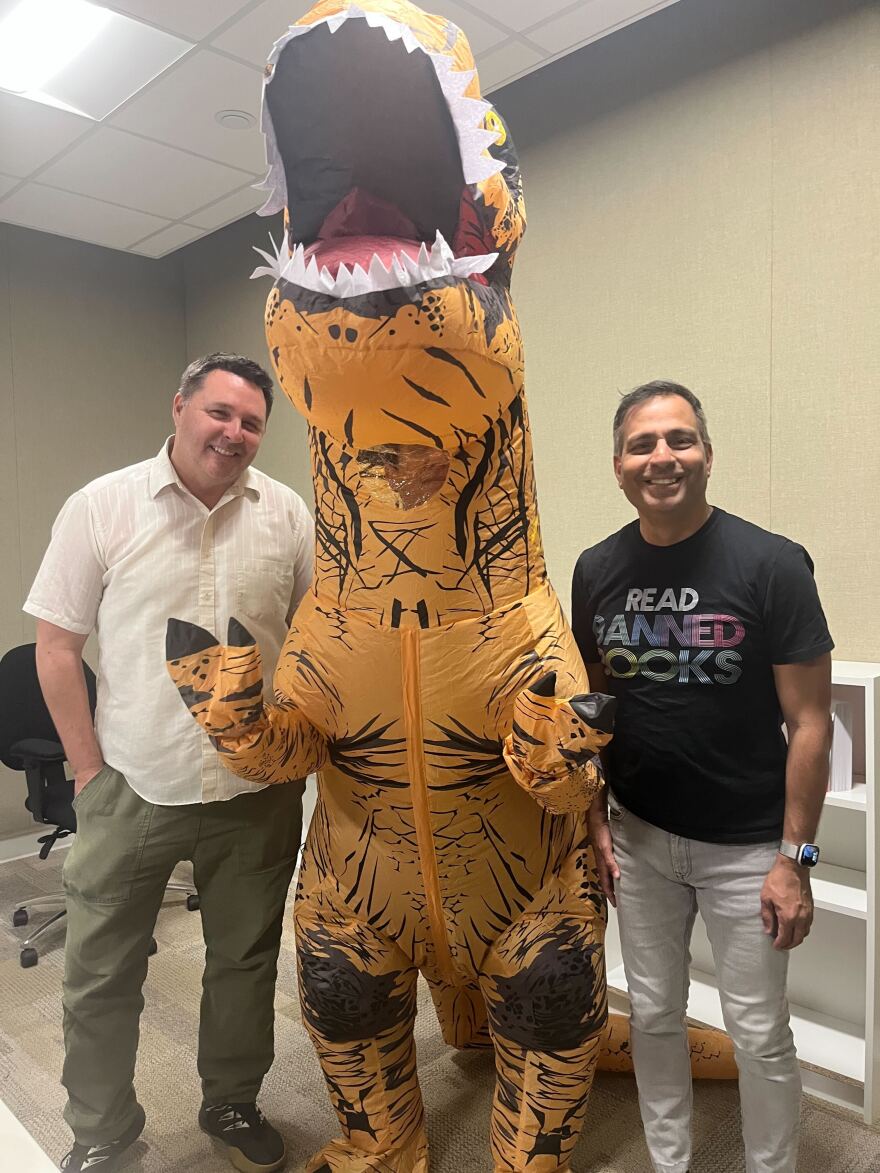 The Midday Movies tactical frivolity team of Andrew Bracken, Beth Accomando (in the T-Rex inflatable) and Movewallas' Yazdi Pithavala. Nov. 19, 2025.