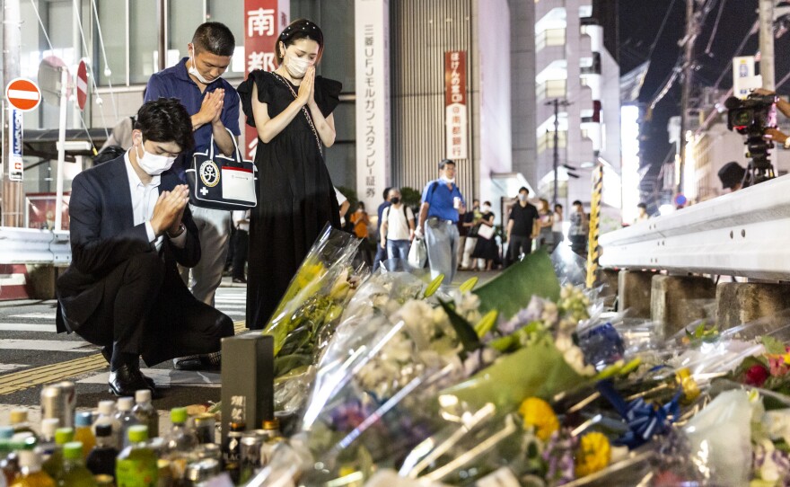 People pray at a site outside of Yamato-Saidaiji Station where former Prime Minister Shinzo Abe was shot earlier Friday during an election campaign speech, in Nara, Japan.