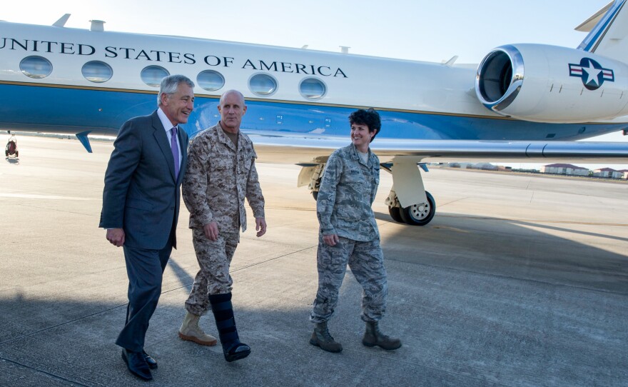 U.S. Secretary of Defense Chuck Hagel, left, walks with Vice Adm. Robert Harward, center, the deputy commander of U.S. Central Command, and Col. Kelly Martin, the vice commander of 6th Air Mobility Wing, after landing at MacDill Air Force Base, Tampa, Fla., March 21, 2013.