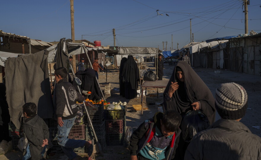 People stroll through the marketplace in the al-Hol detention camp on Jan. 30, 2025 in northeastern Syria's Hassakeh province, where tens of thousands of mostly women and children linked to ISIS have been living for years.