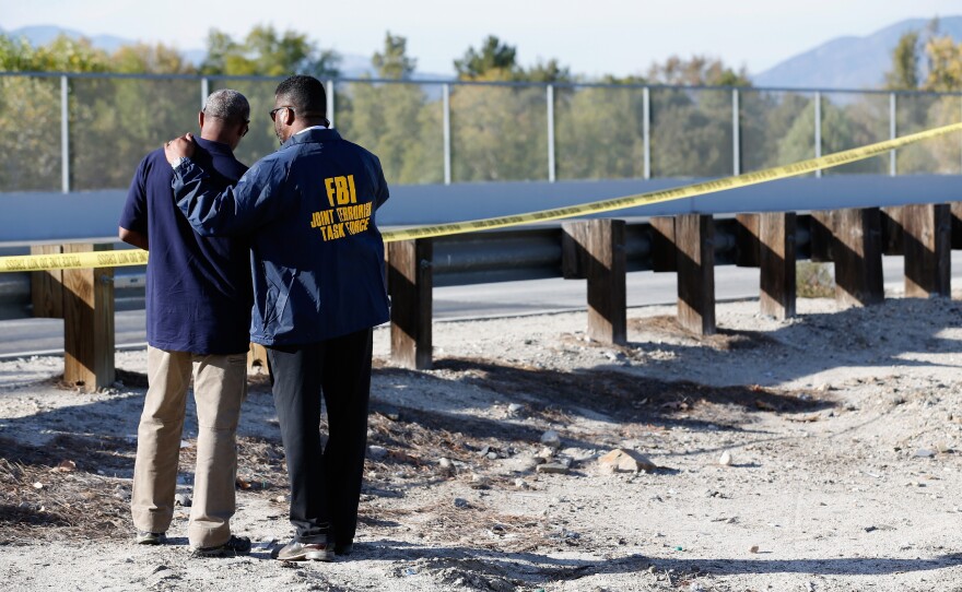 The FBI also responded to the scene. Here, members of the Joint Terrorism Task Force stand outside a press conference about the shooting.