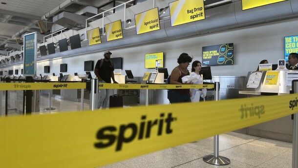Travelers walk past the Spirit Airlines check-in counter at San Diego International Airport Terminal 1, Sept. 4, 2025.