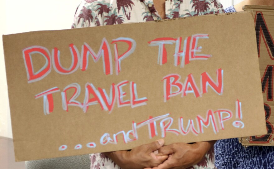 A demonstrator holds a sign protesting the travel ban in Honolulu in June. The 9th Circuit Court of Appeals on Thursday sued the latest ruling against the Trump administration's order.