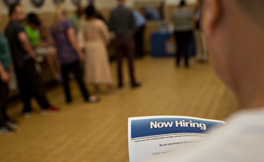 The U.S. has added jobs in every month for nearly eight years. Here, a job seeker holds an employment flyer during a hiring event at an Aldi Supermarket in Darien, Ill., in July.