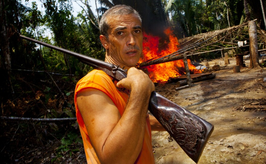 Elizeu Berçacola surveys the scene after he and his fellow rubber tappers set afire one of three illegal logging camps.