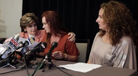 Attorney Gloria Allred, left, puts an arm around nurse Michelle Tyler after she spoke at a news conference with former Marine Katherine Ragazzino, right, Aug. 6, 2013, in San Diego. Tyler alleged inappropriate sexual behavior by San Diego Mayor Bob Filner at a June meeting where she was asking for help for Ragazzino, an injured former Marine.