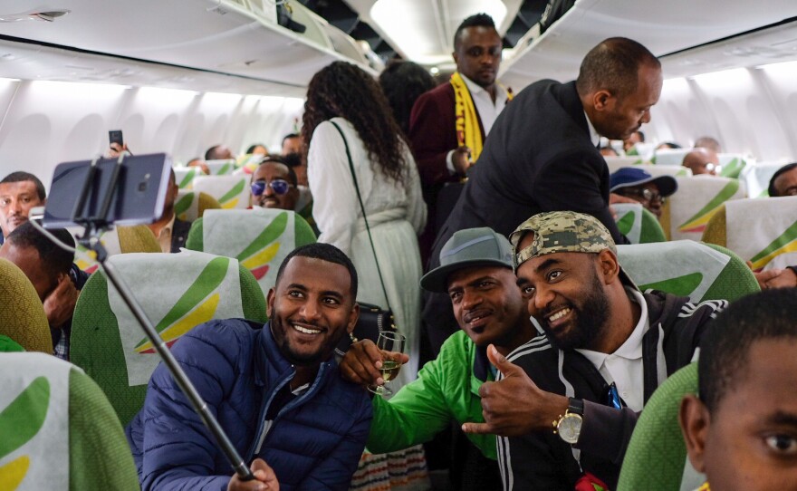Passengers pose for a selfie picture inside an Ethiopian Airlines plane that departed from Bole International Airport in Addis Ababa, Ethiopia, and flew to Eritrea's capital, Asmara, on Wednesday. It was the first commercial flight between the two African countries in two decades.
