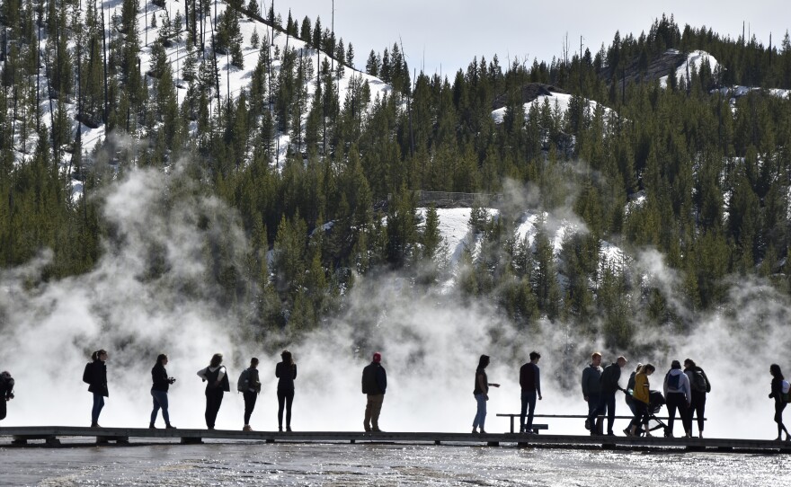 Visitors are seen at Grand Prismatic Spring in Yellowstone National Park, Wyo., last year.