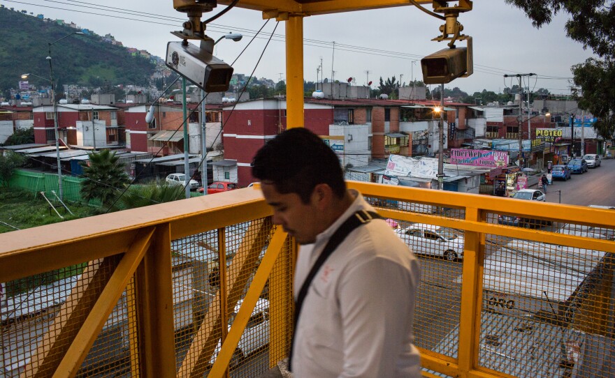 A man walks by security cameras in the Guelatao Metro station in Mexico City. The cameras are operated by Mexico City Public Transit. This is part of a larger visual project focused on violence in the Mexican capital.