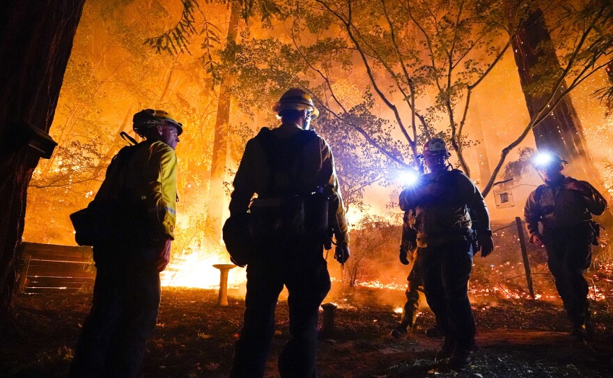 Firefighters make a stand in the backyard of a home in front of the advancing C.Z.U. Lightning Complex fire on Friday. California is seeing some of the worst first in the state's history.