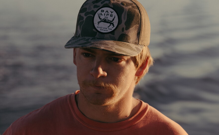 Jack Torney steers his crab boat as he prepares to haul up lines loaded with blue crabs.