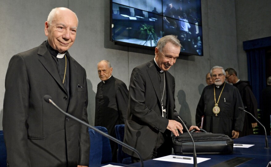 Cardinal Francesco Coccopalmerio, left, president of the Vatican Pontifical Council for Legislative Texts, arrives to read Pope Francis' statement on marriage annulment reforms at the Vatican Tuesday.