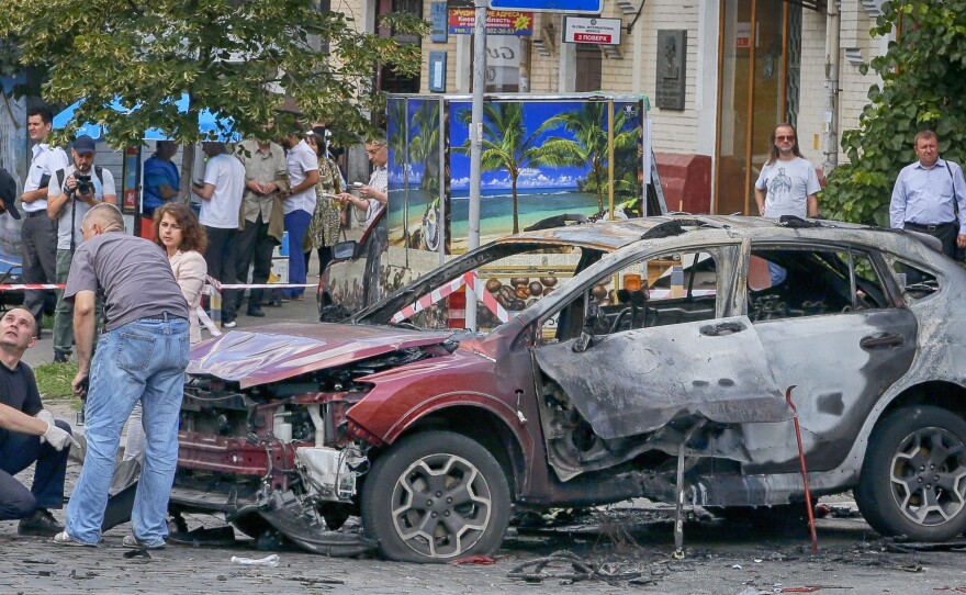 Forensic experts examine the wreckage of a car that exploded, killing prominent investigative journalist Pavel Sheremet, in Kiev, Ukraine, on Wednesday.