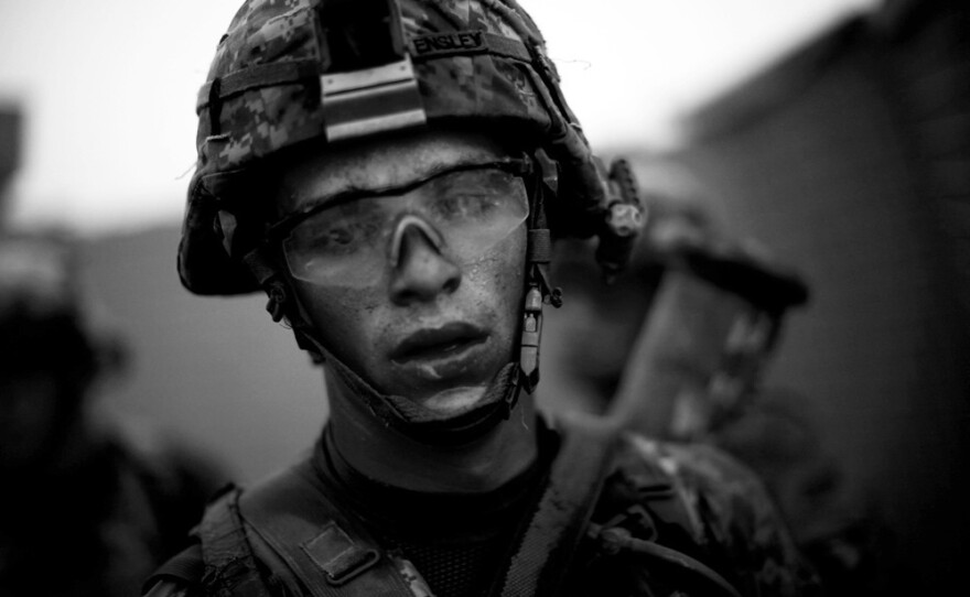 Bravo Company's Pvt. Cody Lee Ensley walks through the safety of the gates at an American base after a daylong fierce attack by insurgents near Payendi. From the story "Signs Of Traction In U.S. Fight Against Afghan Taliban," 2010. 